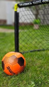 an orange soccer ball sitting next to a goal at Къща за гости Песента на колелетата - Жеравна in Zheravna