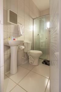 a bathroom with a toilet and a sink and a shower at Praieiro pousada in Prea +40 photos