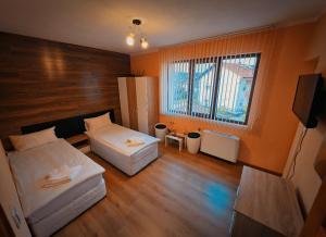 a small room with two beds and a television at Къща за гости Коларски in Sapareva Banya