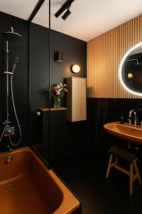 une salle de bain avec une baignoire et un lavabo dans l'établissement Villa ACMÉ 200 m du lac d'Annecy avec Jacuzzi, à Rovagny