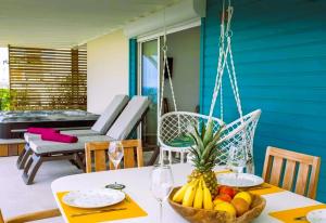 a table with a bowl of fruit on a porch at Oasis d'Happy Bay with SPA, Frontbeach, Amazing sunset on Anguilla in Friar's Bay
