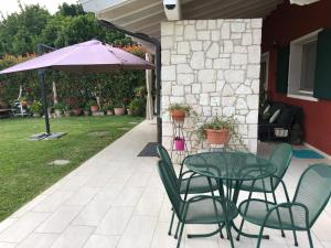 a table and chairs with an umbrella on a patio at Vita sul Garda in Bardolino