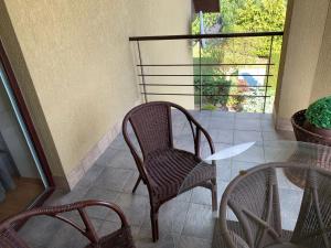 a patio with two chairs and a table and a window at Green Garden Apartments in Kaunas