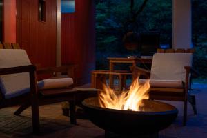 a fire pit in a room with two chairs and a table at Private Villa 3 minutes from bus stop - in the meantime in Hakone +35 photos