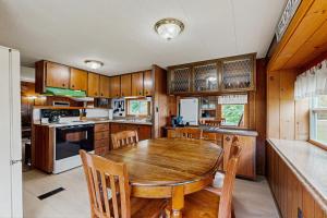a kitchen with a wooden table and wooden cabinets at Riverbank's Pemi Cottage in Lincoln