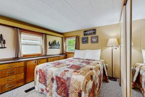 a bedroom with a bed and a window at Riverbank's Pemi Cottage in Lincoln +22 photos