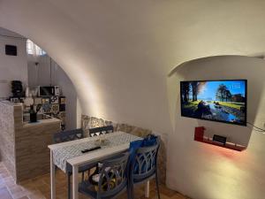 a dining room with a table and a tv on a wall at Da Matteo in Gaeta