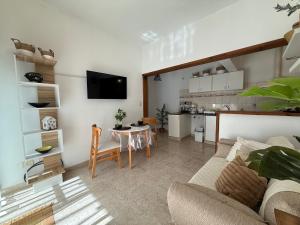 a living room with a couch and a table and a kitchen at VIA VALENTINA "el deseo de volver" departamentos temporales sobre Av Eden centro in La Falda