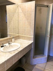 a bathroom with a sink and a shower at Villa Arroyo, Estuary Estate, Port Edward in Port Edward