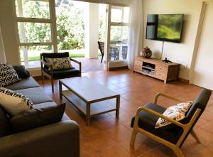 a living room with a couch and a tv at Villa Arroyo, Estuary Estate, Port Edward in Port Edward