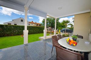 a table with a bowl of fruit on a patio at Apartments Pilic in Rošini