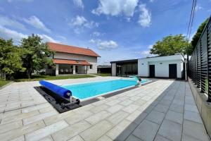 una piscina con un galleggiante blu accanto a una casa di Vila Magnolija Ilidža a Sarajevo