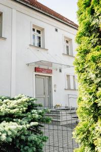 a white building with a fence in front of it at B&B Wieniawa in Leszno