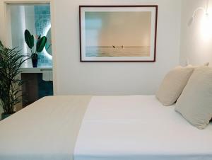 a bedroom with a white bed with a picture on the wall at Santa Cruz - B&B in Lagos +27 photos