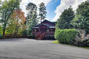 a house with a porch and a fence in front of it at Mountain Treasure by Venture Smoky Mountains in Sevierville +11 photos