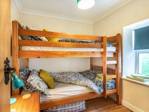 two bunk beds in a room with a desk at Bwthyn Angell 