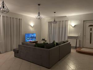 a living room with a couch and a flat screen tv at Margaw's Villa 600m from the beach in Perea