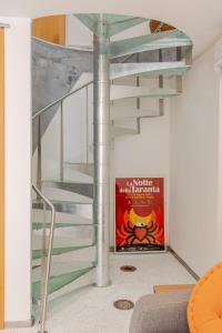 a metal spiral staircase in a room with a poster at Residence Court of the Seminary in Otranto