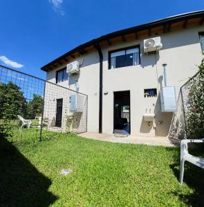 una casa blanca con una valla delante en Amancay, en Villa Elisa