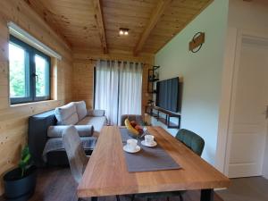 a living room with a wooden table and a couch at Wooden Villa Old Oak Plitvice Lakes in Seliste Dreznicko