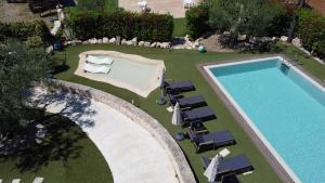an overhead view of a swimming pool with chaise lounge chairs and a swimming pool at La linea dell'orizzonte in Alberobello