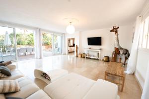 a living room with a white couch and a giraffe statue at CALA JONDAL "Can Amanaya" in Sant Josep de Sa Talaia