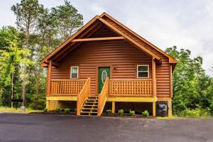 Cette cabane en rondins dispose d'une terrasse couverte et d'un escalier menant à la porte. dans l'établissement The Bear Crossing by Venture Smoky Mountains, à Pigeon Forge