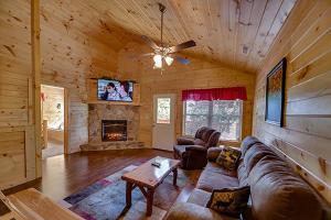 un salon avec un canapé et une cheminée dans l'établissement The Bear Crossing by Venture Smoky Mountains, à Pigeon Forge