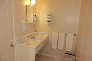 a bathroom with a sink and a mirror and towels at Admiral Digby Inn Restaurant and Cottages in Digby +149 photos