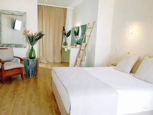 a bedroom with a large white bed and a chair at Santa Cruz - B&B in Lagos
