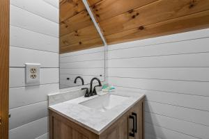 a bathroom with a sink and wooden ceiling at The Hideaway at Grassy Branch by Venture Smoky Mountains in Sevierville +19 photos