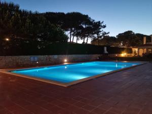 a swimming pool in a backyard at night at Praia D'El Rey - Townhouse Dom Duarte in Amoreira