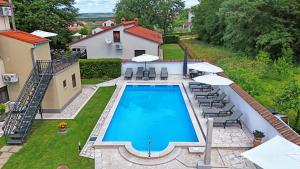 an overhead view of a swimming pool with chairs and umbrellas at Apartments Pilic in Rošini