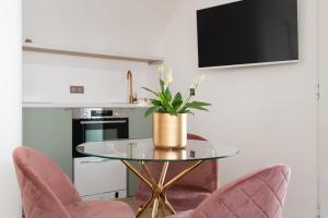 a dining room with a glass table and two pink chairs at Studios Le Médicis in Rouen