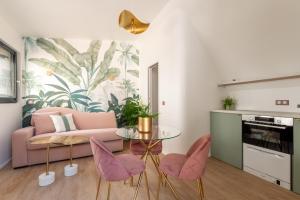 a living room with a pink couch and pink chairs at Studios Le Médicis in Rouen