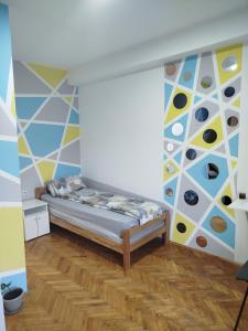 a bedroom with a bed and a wall with colors at V&U Sobe in Brzi Brod