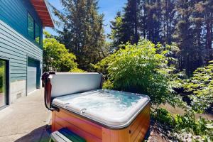 a hot tub sitting on the side of a yard at Whispering Waters Retreat in Pacific City