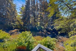 a view of a forest with trees and a river at Whispering Waters Retreat in Pacific City