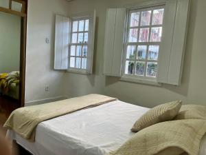 - un lit dans une chambre avec 2 fenêtres dans l'établissement Casa Zara, à Diamantina