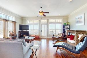 a living room with a couch and a ceiling fan at Cottage House #201 in Corpus Christi