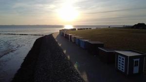 a row of trash cans on the beach at sunset at Appartement Pension Feist in Dagebüll