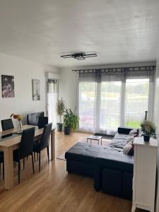 a living room with a couch and a dining room at appartement 5min gare RER Disneyland Paris val d'Europe la vallée Village parking inclus in Montévrain