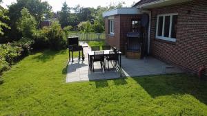 a patio with a table and chairs in a yard at Zimmer Austernfischer in Dagebüll +2 photos