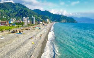 a beach with people laying on the sand and the water at Gonio Horizon Apartment in Gonio