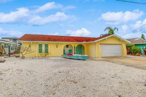 een geel huis met een rood dak en een oprit bij Sunsets and Dolphins in Hernando Beach