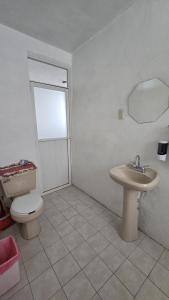 a bathroom with a toilet and a sink at Acogedor y céntrico departamento in Pachuca de Soto
