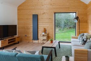 a living room with a blue couch and a television at Willow Lodge Estate in Six Road Ends
