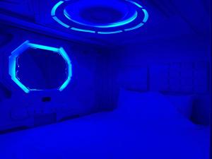 a dark room with a bed with a blue light at Green Caps in Cancún