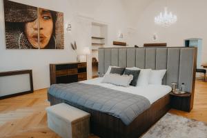 a bedroom with a large bed and a large painting at Contessa Apartments in Košice