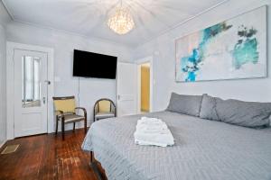 a bedroom with a bed and a flat screen tv at Sinatra House Down Walk to Pleasure Pier and Fun in Galveston